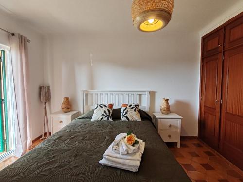 a bedroom with a bed with towels on it at 61 Casa Pitta Manau - Casas & Papéis in Porches