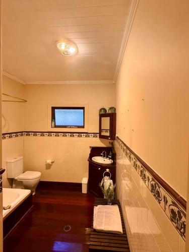 a bathroom with a sink and a tub and a toilet at Korla Cottage, Leura Family & Pet Friendly Stay in Leura