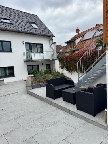 a patio with two black couches in front of a house at F 2 - 2 Zimmer Wohnung in Offenbach