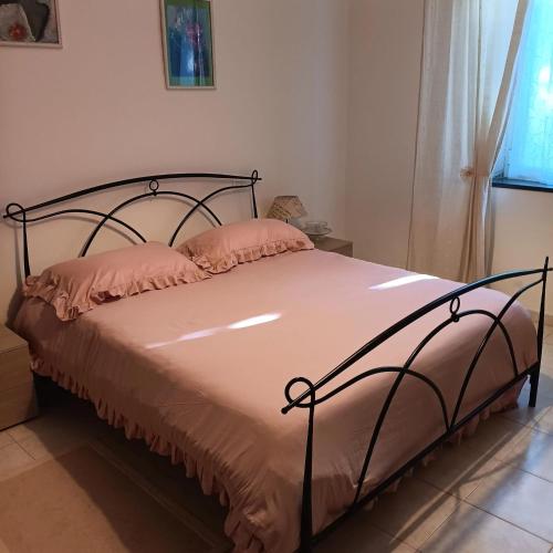 a bedroom with a bed with pink pillows on it at Il Nibbio in Vecchiano