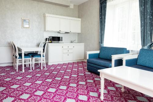 a living room with a couch and a table at Pałac Domaniowski in Wieniawa