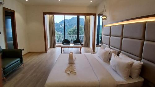 une chambre d'hôtel avec un lit avec une serviette dessus dans l'établissement Lawrence Tungsten Resort, à Nainital
