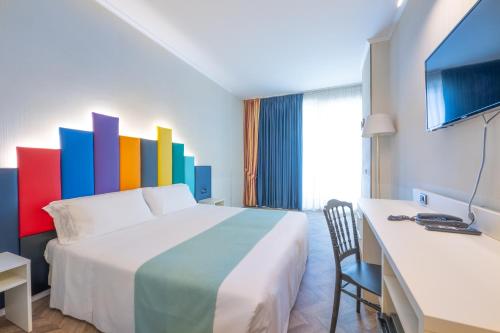 a hotel room with a bed with a colorful wall at Admiral Art Hotel in Rimini