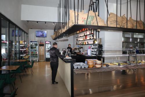 a man standing at a counter in a restaurant at Hotel Omw Vore in Vorë