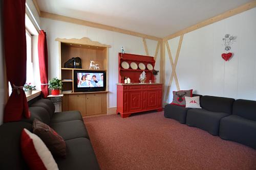 a living room with two couches and a tv at Albergo Majorka in Canazei