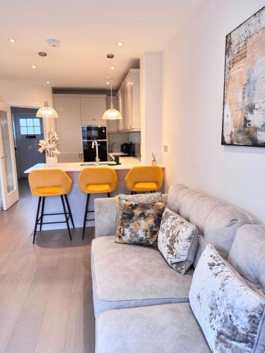 a living room with a couch and a kitchen at Spacious 4-Bedroom House Ideal for Contractors, Families & Business Stays in Reading, Offers 3 Parkings in Burghfield