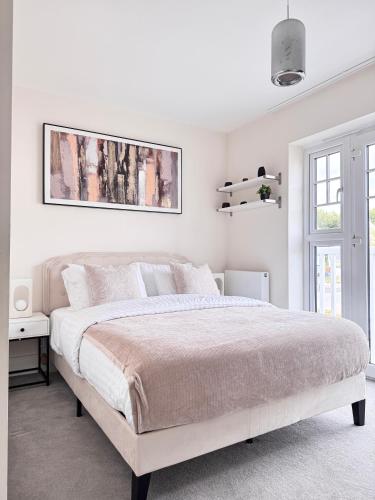 BurghfieldにあるStylish 4BR Apt Serene and Centralの大きなベッドと窓のある白い寝室