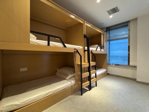 Dos literas en una habitación con ventana. en Third Floor Youth Hostel, en Shanghái