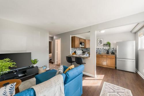 a living room with a blue couch and a kitchen at Apartment Kansas City 15mins to KCI with a KING bed and work desk in Riverside