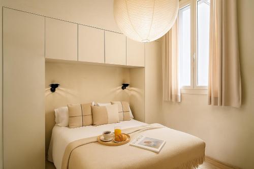 a bedroom with a bed with a tray on it at The Boulevard by Aspasios in Barcelona