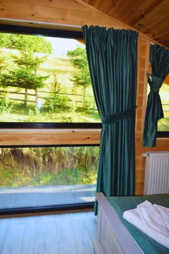 a room with a window with a green curtain at Cabana Cristi in Vatra Dornei