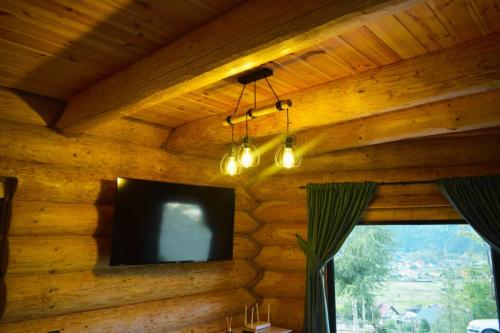 ヴァトラ・ドルネイにあるCabana Cristiの木製の壁から吊るされた薄型テレビ