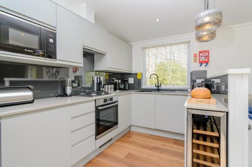 una cucina con mobili bianchi e un piano di lavoro di Landal Rockingham Forest a Wansford