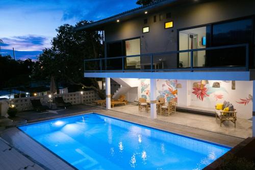 a house with a swimming pool in front of it at Hotel MAMI Resort in Amphoe Koh Samui