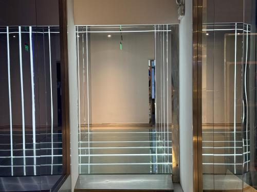 un pasillo con puertas de cristal y escaleras en un edificio en Third Floor Youth Hostel, en Shanghái