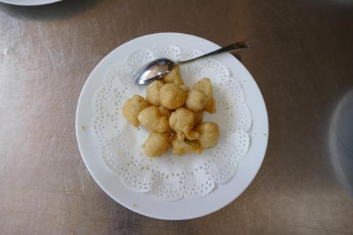 a white plate with tater tots on a spoon at Hotel L'Ulivo in Mirabella Eclano