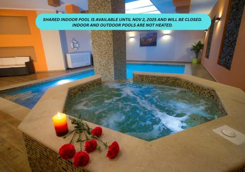 Una gran piscina con una vela y flores rojas en ella. en Villa belvedere, en San Julián