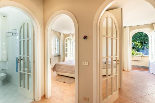 a bedroom with arched doors and a bed at Luxury Villa Forte dei Marmi I Gym & View in Strettoia