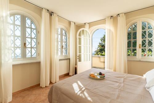 a bedroom with windows and a bed with a bowl of fruit on it at Luxury Villa Forte dei Marmi I Gym & View in Strettoia