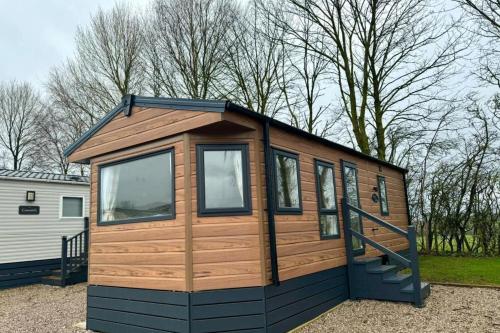 a small cabin with a door and windows at Westfield Lodge Retreat-Sleeps 6-Pet Friendly in Carnforth