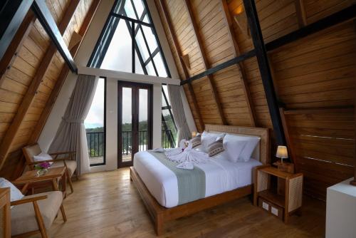 a bedroom with a bed in a room with large windows at Luxury Villas in Munduk at walking distance to Tamblingan Lake in Munduk