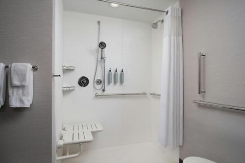 a white bathroom with a shower and a toilet at Courtyard by Marriott Lake City in Lake City