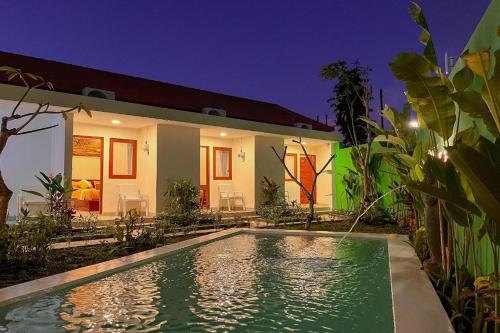 a house with a swimming pool in front of it at Mora Residence in Jimbaran