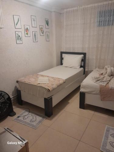 two twin beds in a room with pictures on the wall at Fatih simge in Istanbul