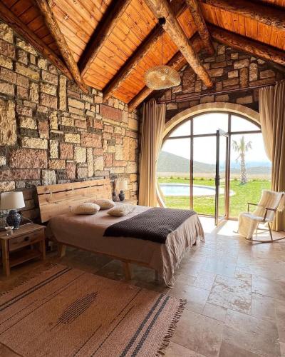 a bedroom with a bed and a stone wall at Ekinoks Hotel in İznik