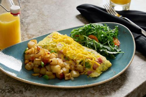 a blue plate with a breakfast of omelet and potatoes and a salad at Sheraton Kansas City Hotel at Crown Center in Kansas City