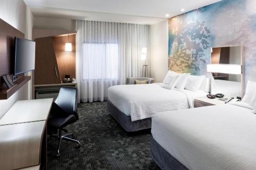 ザ・ウッドランズにあるCourtyard by Marriott Houston North/Shenandoahのベッド2台と机があるホテルの部屋