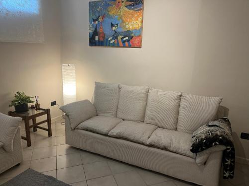 un sofá blanco en una sala de estar con una pintura en Casa Carlotta, en Nizza Monferrato
