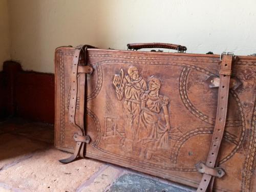 an old suitcase with a painting on the side of it at Hotel Cacique Real in Zipaquirá