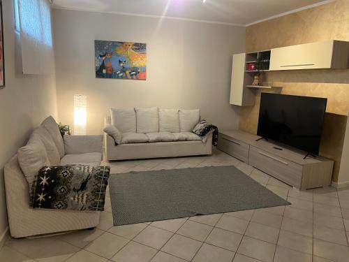 Una sala de estar con un sofá y un televisor de pantalla plana. en Casa Carlotta, en Nizza Monferrato
