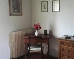 a room with a table with a vase of flowers on it at Colombaio In Colle in SantʼAngelo in Colle