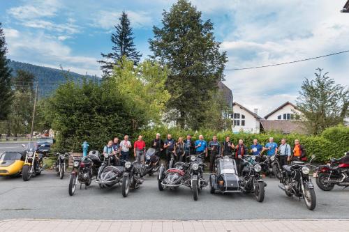 a group of people standing in a parking lot with motorcycles at Gasthof - Pension Durnthaler in Tröpolach
