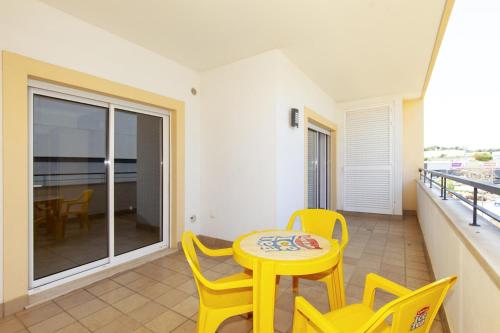 a small yellow table and chairs on a balcony at A05 - Luxury 1 Bed Fully Equipped with Pool in Lagos