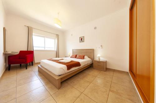a bedroom with a bed and a red chair at A05 - Luxury 1 Bed Fully Equipped with Pool in Lagos