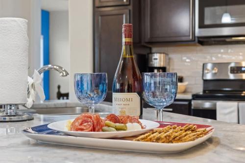 a bottle of wine and a plate of food and wine glasses at NEW Temple House - 12PPL - Families, Groups, Insurance - Quiet Street, 5 Mi To Meta, BS&W, UMHB Pets OK, FAST Wi-Fi FREE Parking - Professionally Managed By Stay Albatross Furnished Rentals in Temple