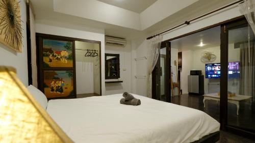 a teddy bear sitting on a bed in a bedroom at Hotel MAMI Resort in Amphoe Koh Samui