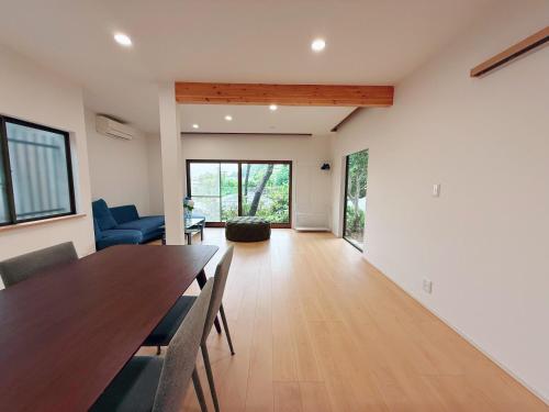 a dining room with a table and a living room at Okayama Garden House Near Station Free Parking in Okayama
