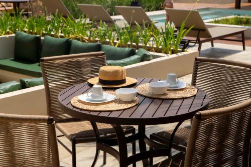 Una mesa de madera con dos sombreros y tazas encima. en Casas Gengibre, en Alto Paraíso de Goiás