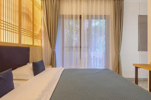 a bedroom with a large bed and a window at Heinemann Hotel courtyard or terrace king room B208 with a jacuzzi and a local in Baoguosi