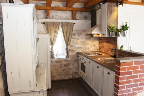 La cuisine est équipée d'un réfrigérateur blanc et d'un évier. dans l'établissement Holiday Home Cvita, à Lozovac