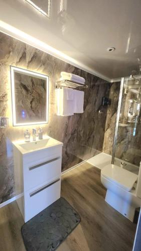 a bathroom with a sink and a shower and a toilet at Carberry Lodge in Musselburgh