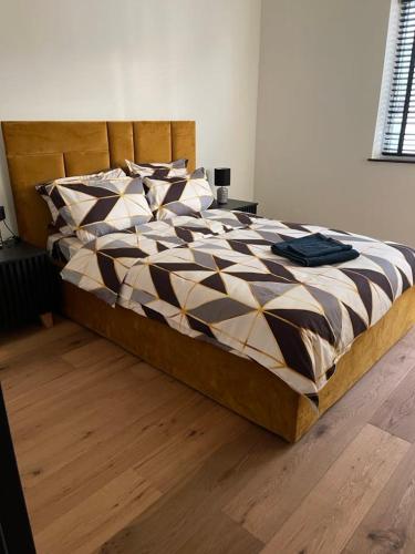 a large bed in a bedroom with a wooden floor at Cristina Apartment in Râşnov