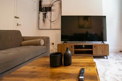 a living room with a couch and a television at Modern 4BR Home in Dudley in Netherton