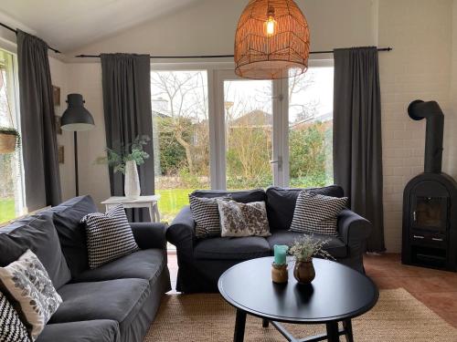 a living room with a couch and a table at Bungalow 007 in Petten