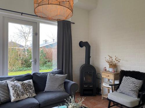 a living room with a couch and a wood stove at Bungalow 007 in Petten