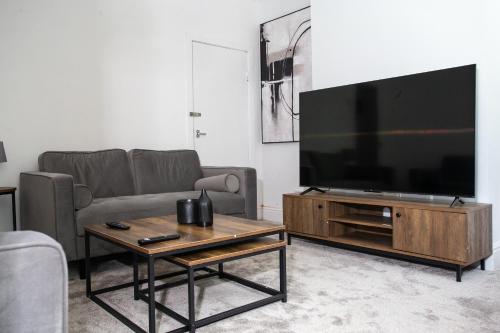a living room with a large flat screen tv at Modern 4BR Home in Dudley in Netherton